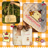 A collage showing a cream-colored Pompompurin handbag held by a hand in front of green foliage, a close-up of a cream gingham fabric patch with embroidered Pompompurin and the text 'POMPOMPURIN', a model wearing a matching cream gingham top with an embroidered Pompompurin patch, and decorative cartoon illustrations on a yellow and white checkered background.