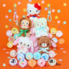 A collection of Sanrio character plush toys and matching round keychains arranged on a bright orange background with star confetti. Visible characters include Hello Kitty, a monkey, a white bunny, a bear, and a light blue animal, each with a small round accessory bag attached.