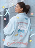 Person wearing a denim jacket with Cinnamoroll designs against a gray wall.