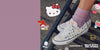 Converse x Hello Kitty and Friends shoes with cartoon character stickers on a concrete floor.