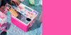 Pink cooler box with Sanrio designs on a blue surface.