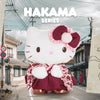 Hello Kitty character in a Hakama outfit standing on a street with traditional Japanese architecture.