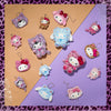 Collection of colorful Hello Kitty and Friends Leopard Keychain Mascots on a patterned surface.