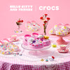 Hello Kitty and Friends Crocs shoes on a pink tablecloth with flowers and tea set.