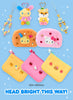 A promotional collage showing several plush zip pouches and matching charm keychains on a light blue background with sparkles. The products include pastel yellow, pink, and orange fuzzy pouches with character faces, plus matching hanging charms.