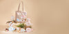Collection of small plush toys and a tote bag with cartoon character designs on a beige background