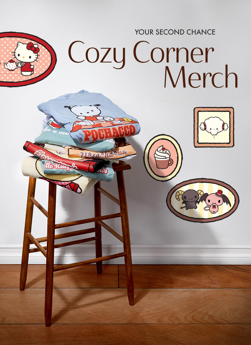 Stack of clothing on a stool with 'Cozy Corner Merch' branding and cartoon character illustrations.